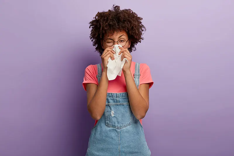 Image showing a person sneezing into a tissue